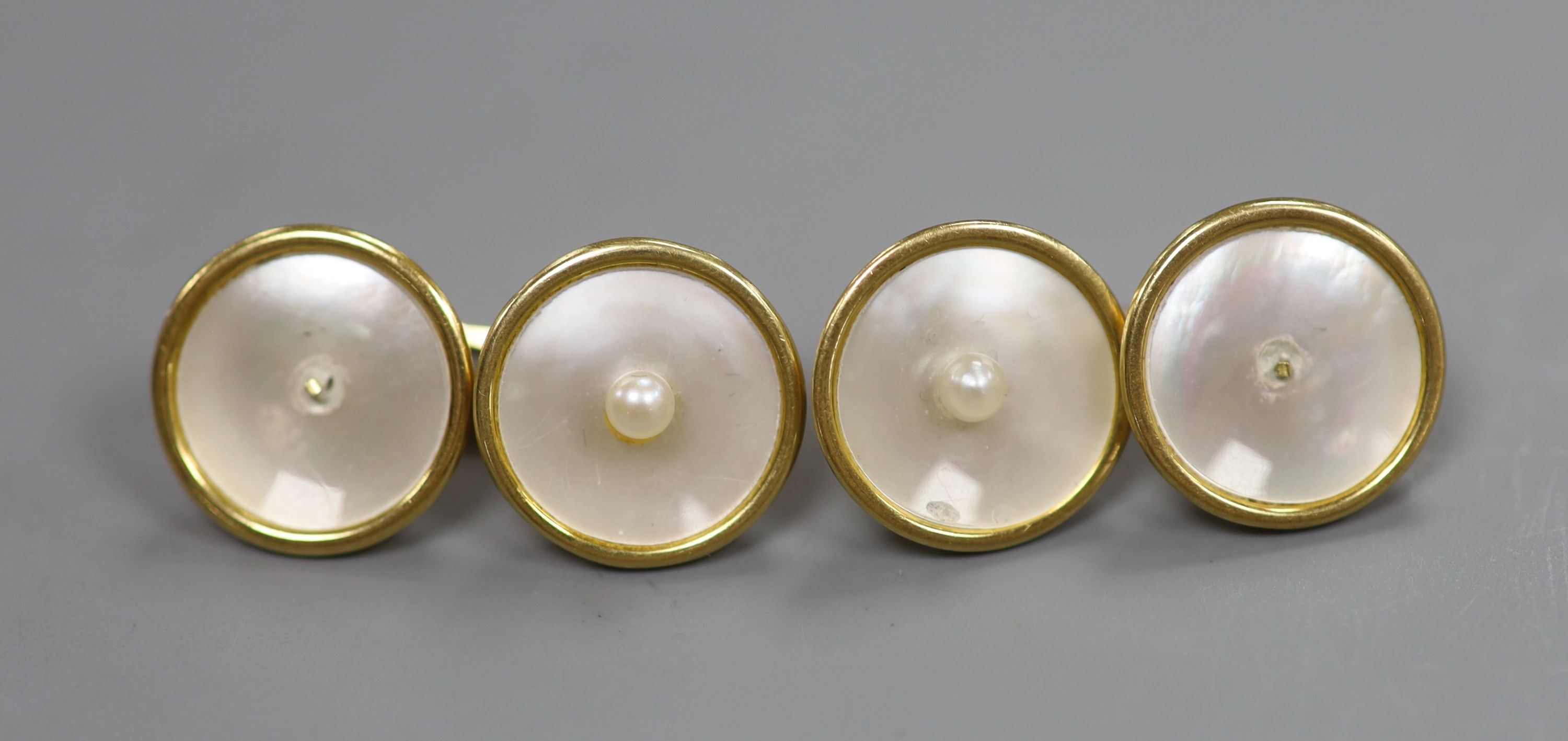 A pair of yellow metal(stamped 18), mother of pearl and seed pearl set disc cufflinks( 2 pearls missing), 14mm, gross 8.7 grams.